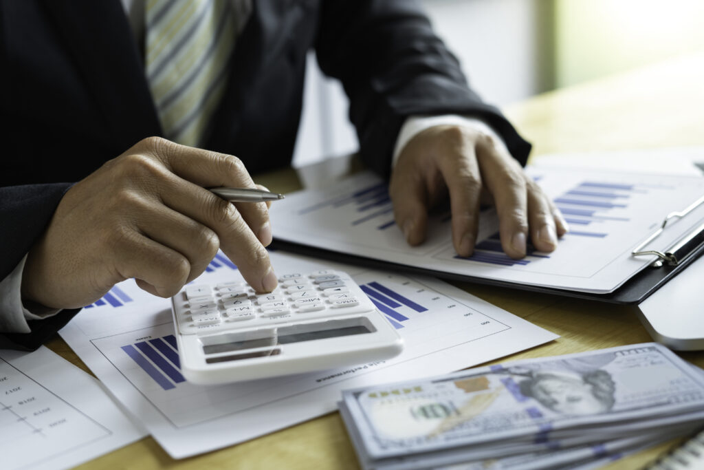 Image of man calculating income gained from investments with a calculator.