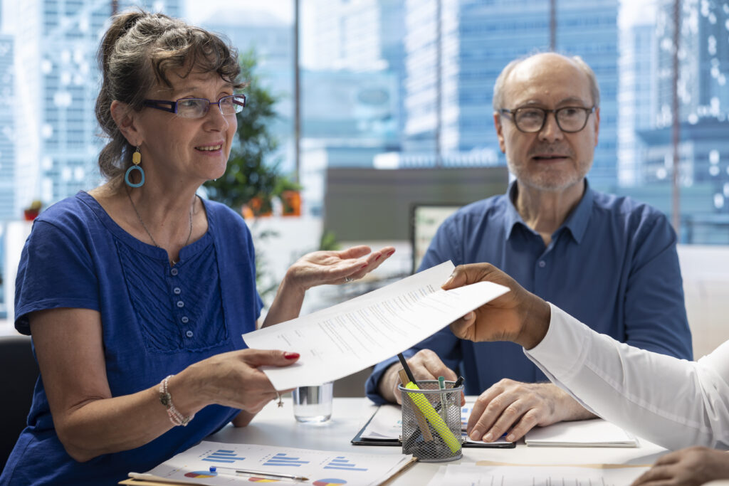 Financial advisor giving the TFRA retirement plan documents to older couple.